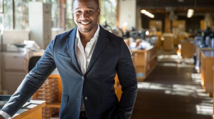 Handsome attractive african american modern professional smile standing confidently at the large interior workspace